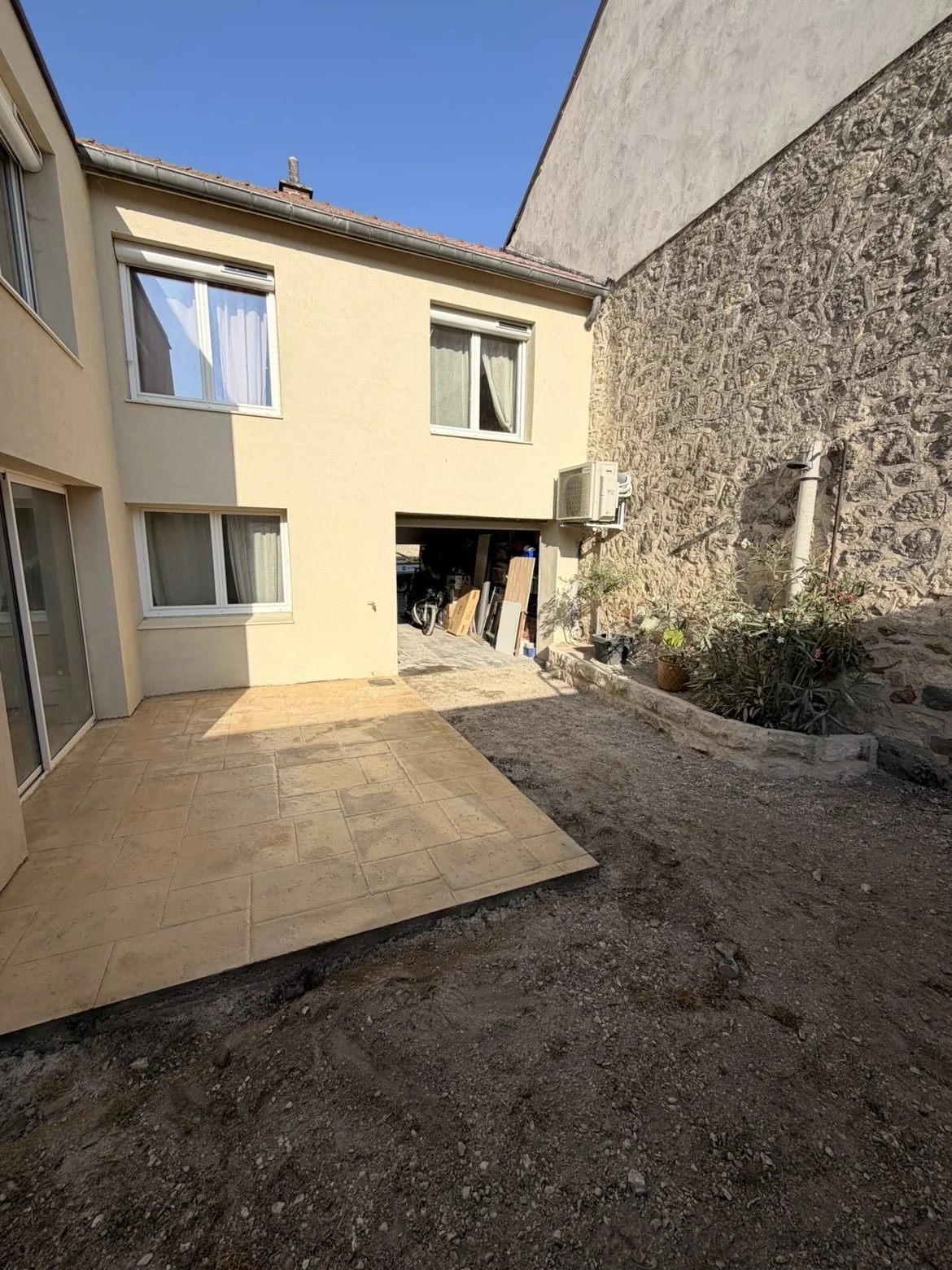 Vue de la terrasse et de la jardinière en pierre dans la cour à Fresne-lès-Reims — SAS DERVAUX